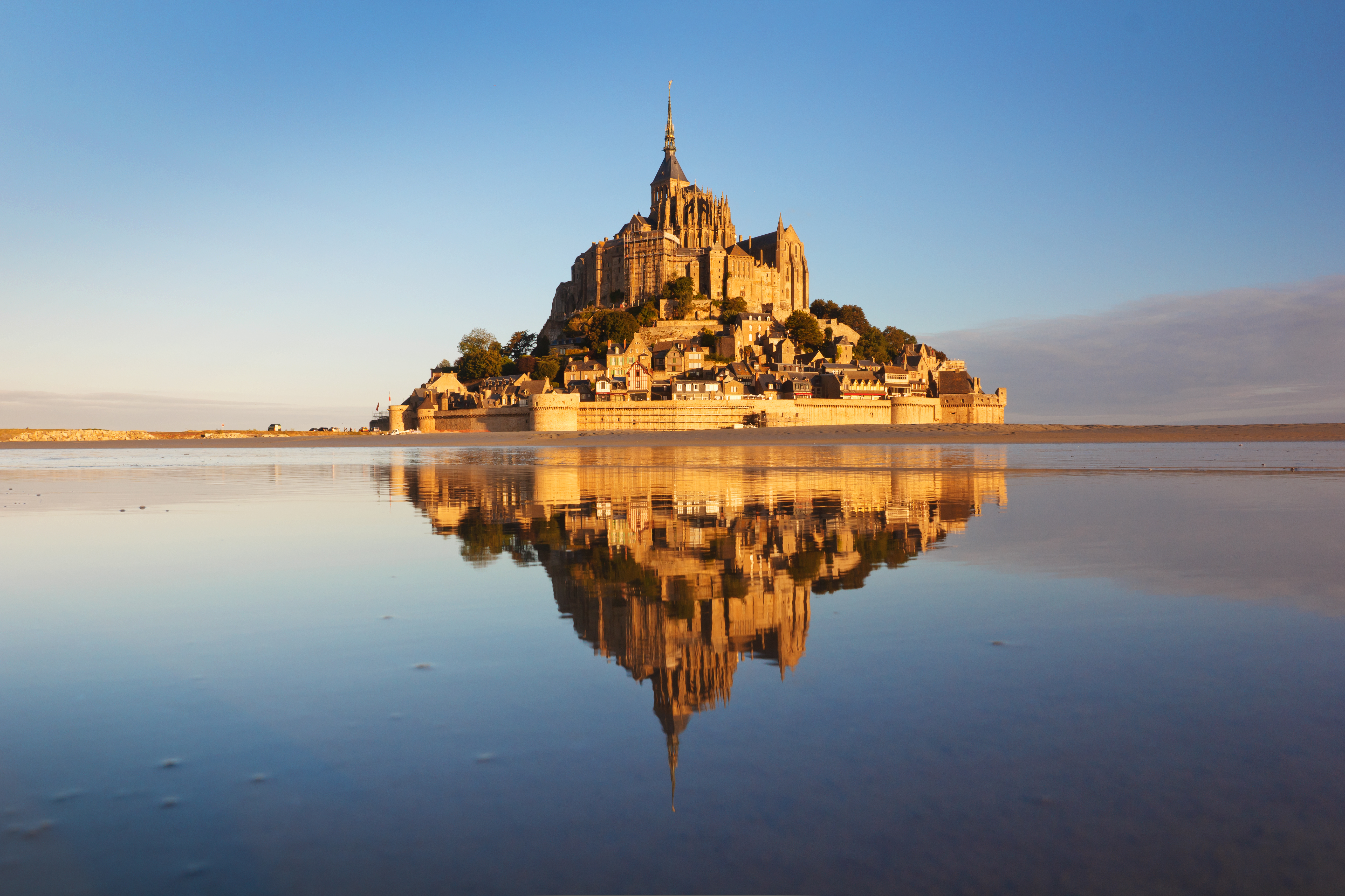 Mont Saint-Michel klosteret spejler sig i vandet ved solnedgang i Normandiet, Frankrig - historisk seværdighed
