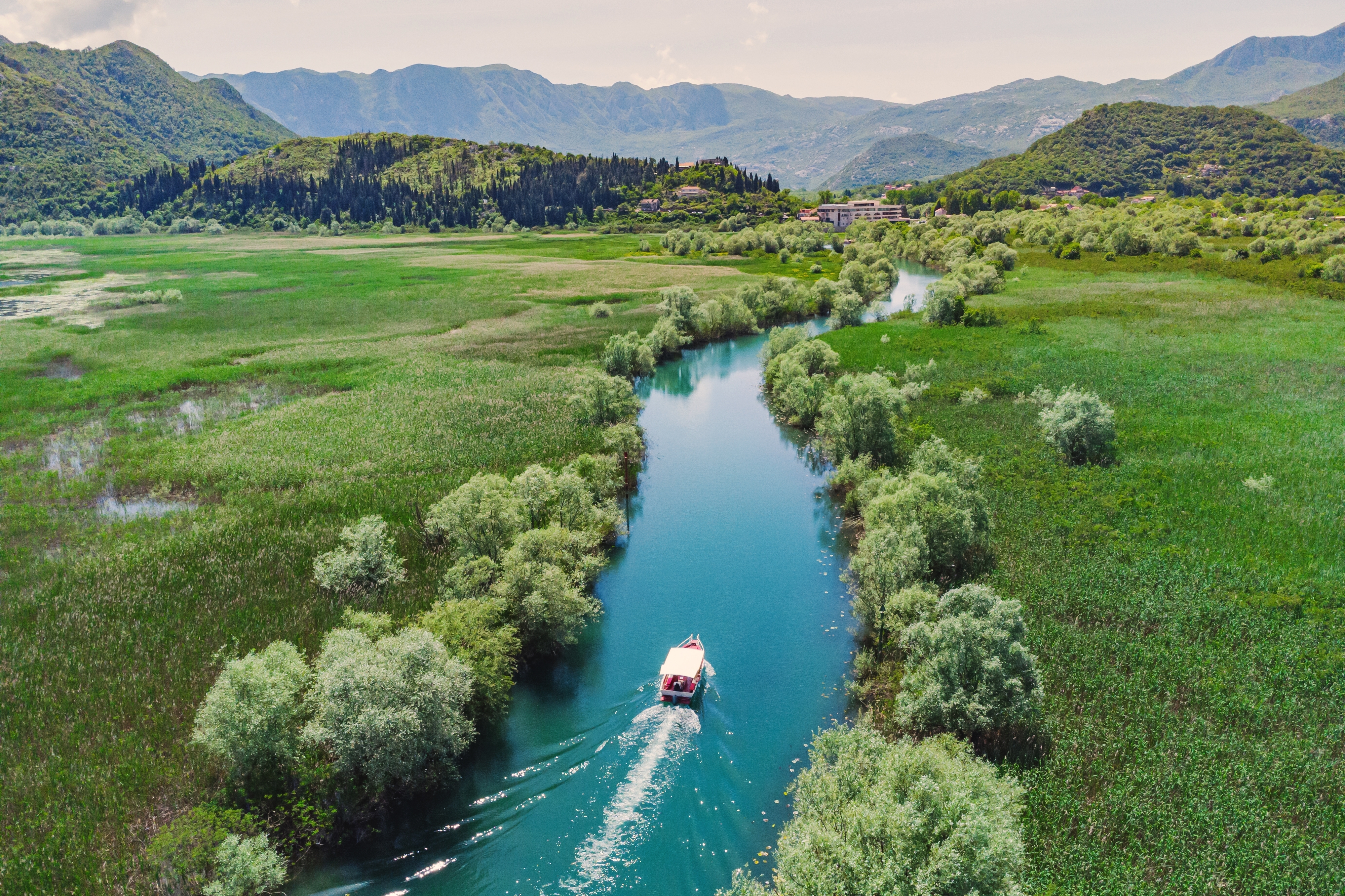 Malerisk bådudflugt gennem turkisblå flod i Montenegro nationalpark med frodigt grønt landskab