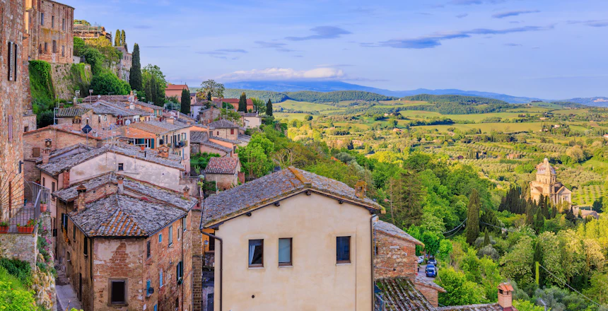 Panoramaudsigt over den middelalderlige bjergby Montepulciano med tegltagshuse og det smukke toscanske landskab i baggrunden, Italien