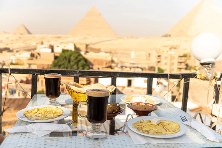 Morgenmad med kaffe og æg med udsigt til Giza-pyramiderne i Cairo, Egypten