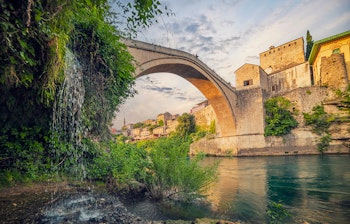 Den berømte Stari Most bro over Neretva floden i Mostar, Bosnien-Herzegovina med middelalderlige stenbygninger