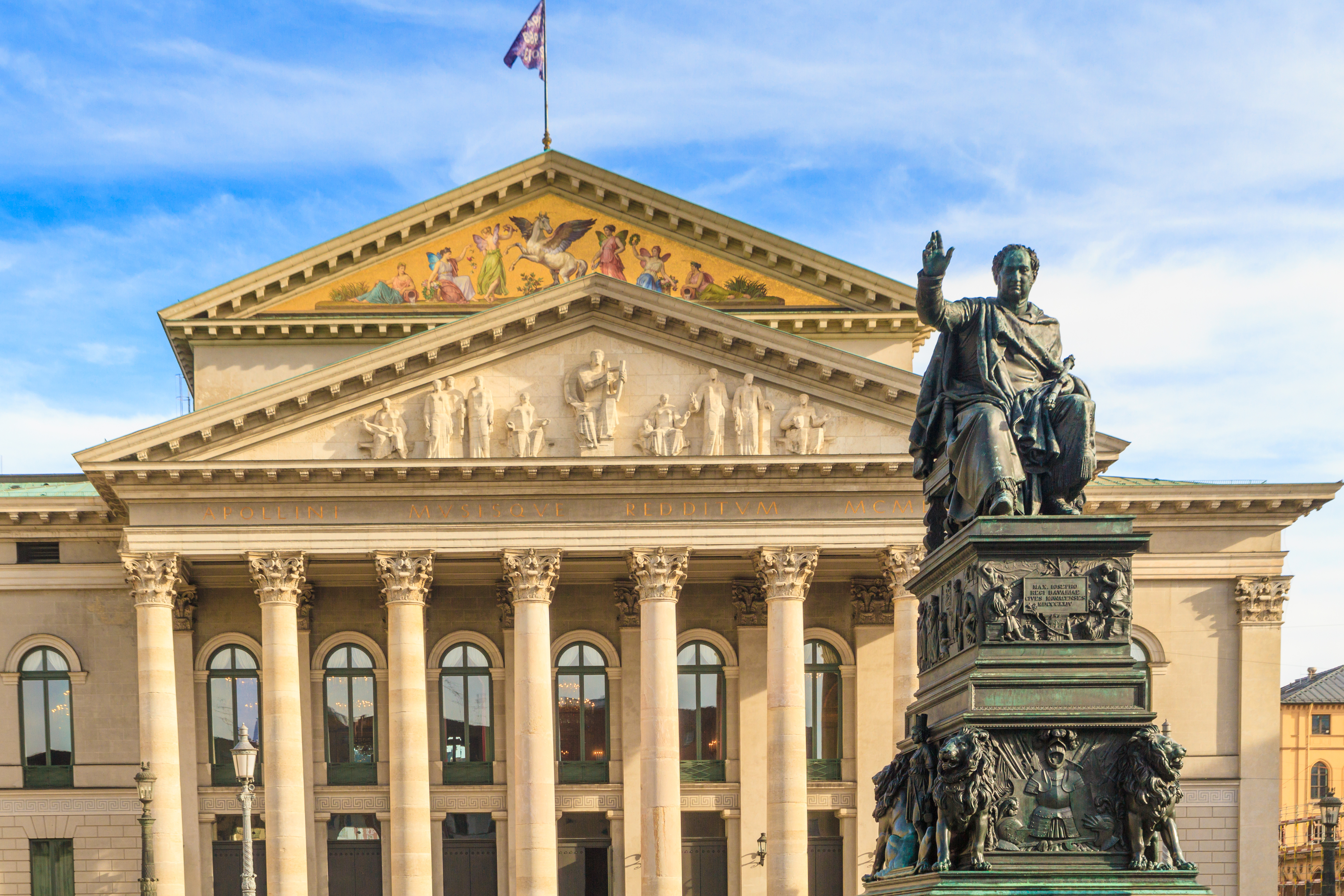 Münchens statsopera med klassiske søjler og Kong Maximilian statue på Max Joseph Plads i Bayern