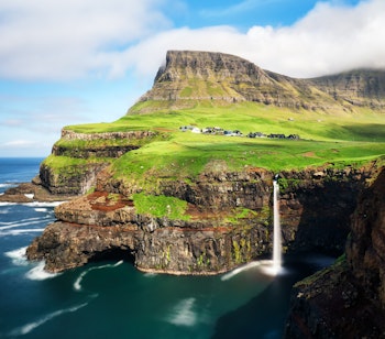 Det majestætiske Múlafossur vandfald der styrter ned i havet ved den idylliske landsby Gásadalur på Vágar-øen, Færøerne