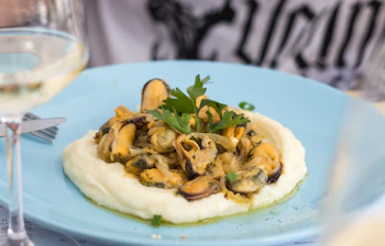 Lækre muslinger med persille serveret på cremet kartoffelmos med hvidvin