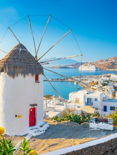 De berømte hvide vindmøller i Mykonos by med udsigt over det azurblå Ægæerhav, et ikonisk vartegn i det græske øhav