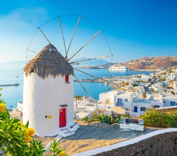 De berømte hvide vindmøller i Mykonos by med udsigt over det azurblå Ægæerhav, et ikonisk vartegn i det græske øhav