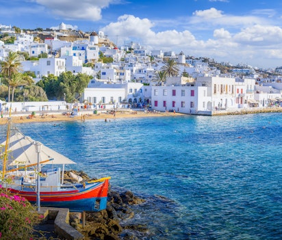 Panoramaudsigt over Mykonos by (Chora) med traditionelle hvidkalkede bygninger, snævre gader og blå detaljer med kig til det Ægæiske Hav