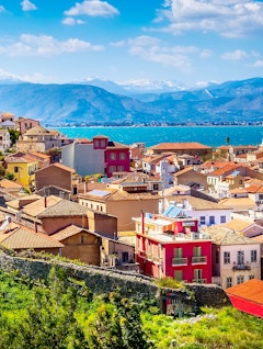 Luftpanorama over Nafplios historiske gamle bydel med røde tage og snedækkede bjerge i Peloponnes, Grækenland