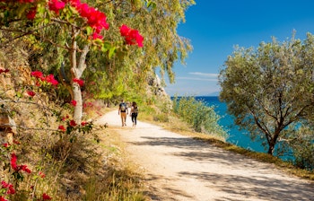 Idyllisk kyststi med udsigt til Palamidi-fæstningen og det azurblå Middelhav i historiske Nafplio, Grækenland