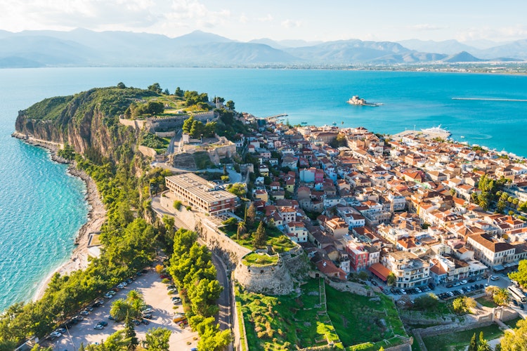 Luftfoto over Nafplio med den ikoniske Bourtzi-fæstning i havet og bjergene i baggrunden, Peloponnes, Grækenland
