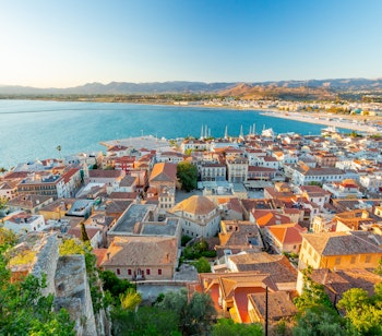 Betagende panoramaudsigt over Nafplio set fra Palamidi-fæstningen med byens karakteristiske røde tegltage, den blå bugt og bjergene i baggrunden på Peloponnes-halvøen