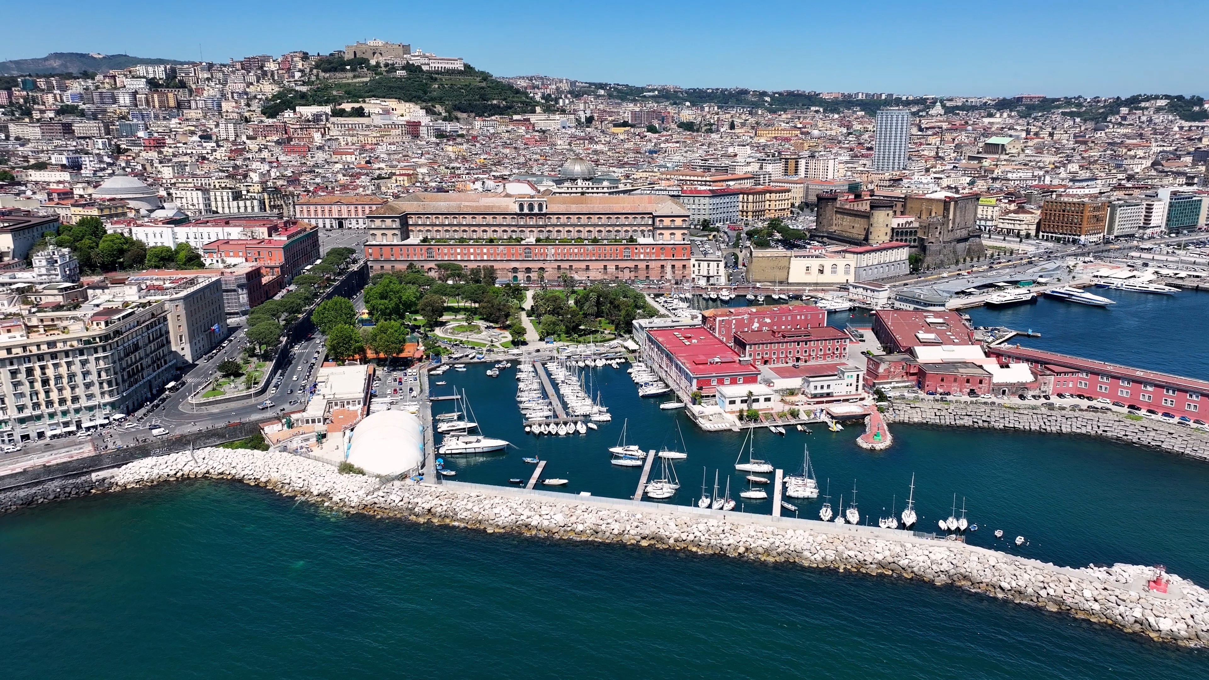Luftfoto over Napoli med det Kongelige Palads, marina med sejlbåde og den smukke kystlinje ved Napoli-bugten i Italien