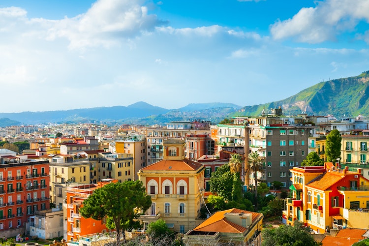 Farverige bygninger og arkitektur i Napoli Italien med bjerge i baggrunden