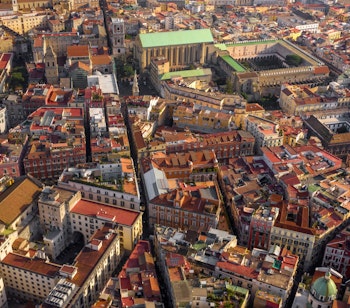 Luftfoto af Napolis historiske centrum med røde tegltage og Santa Chiara Basilika