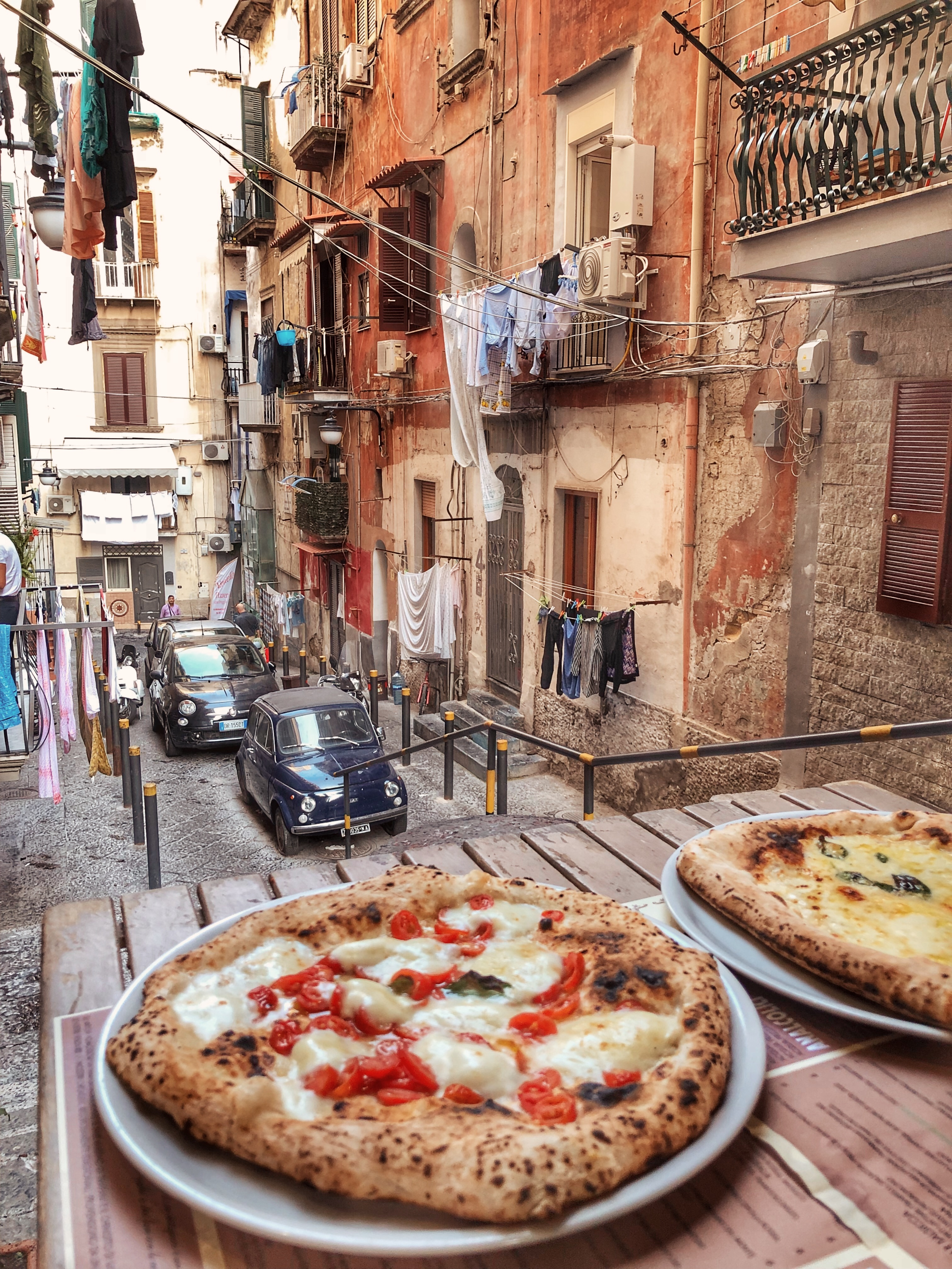 Autentisk napolitansk pizza Margherita på terrasse med udsigt over smalle gader i historiske Napoli Italien