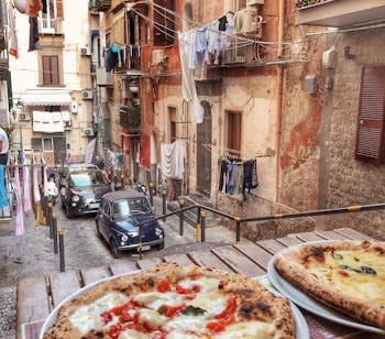 Autentisk napolitansk pizza Margherita på terrasse med udsigt over smalle gader i historiske Napoli Italien