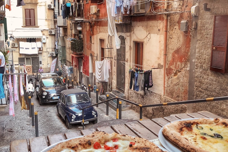 Autentisk napolitansk pizza Margherita på terrasse med udsigt over smalle gader i historiske Napoli Italien