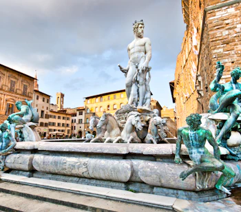 Den berømte Neptunfontæne med sin imponerende marmorskulptur af havguden på Piazza della Signoria i Firenze med historiske bygninger i baggrunden
