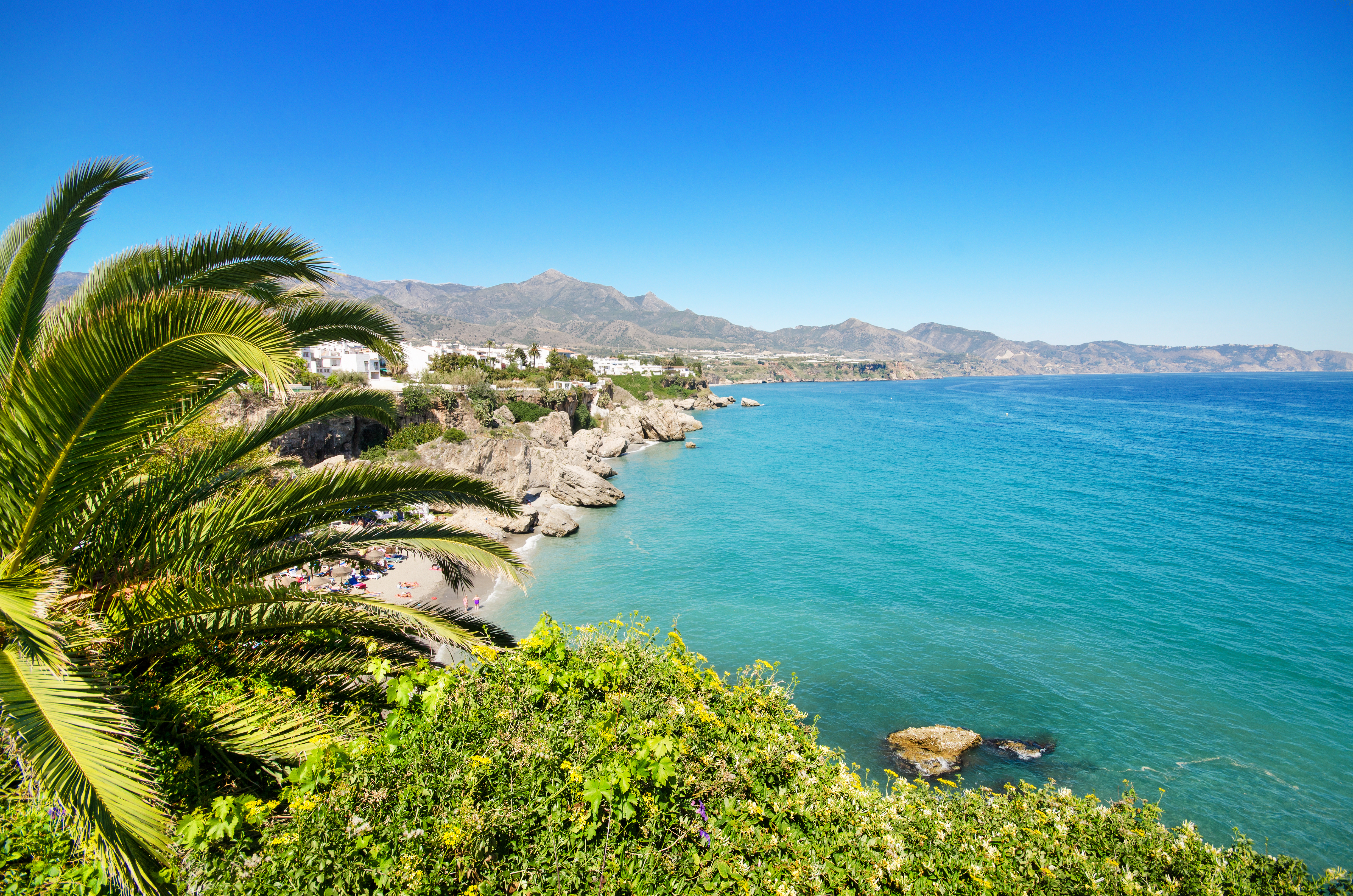 Malerisk udsigt over Nerjas kystlinje med det blå Middelhav og hvide bygninger langs Costa del Sol i Andalusien, Sydspanien