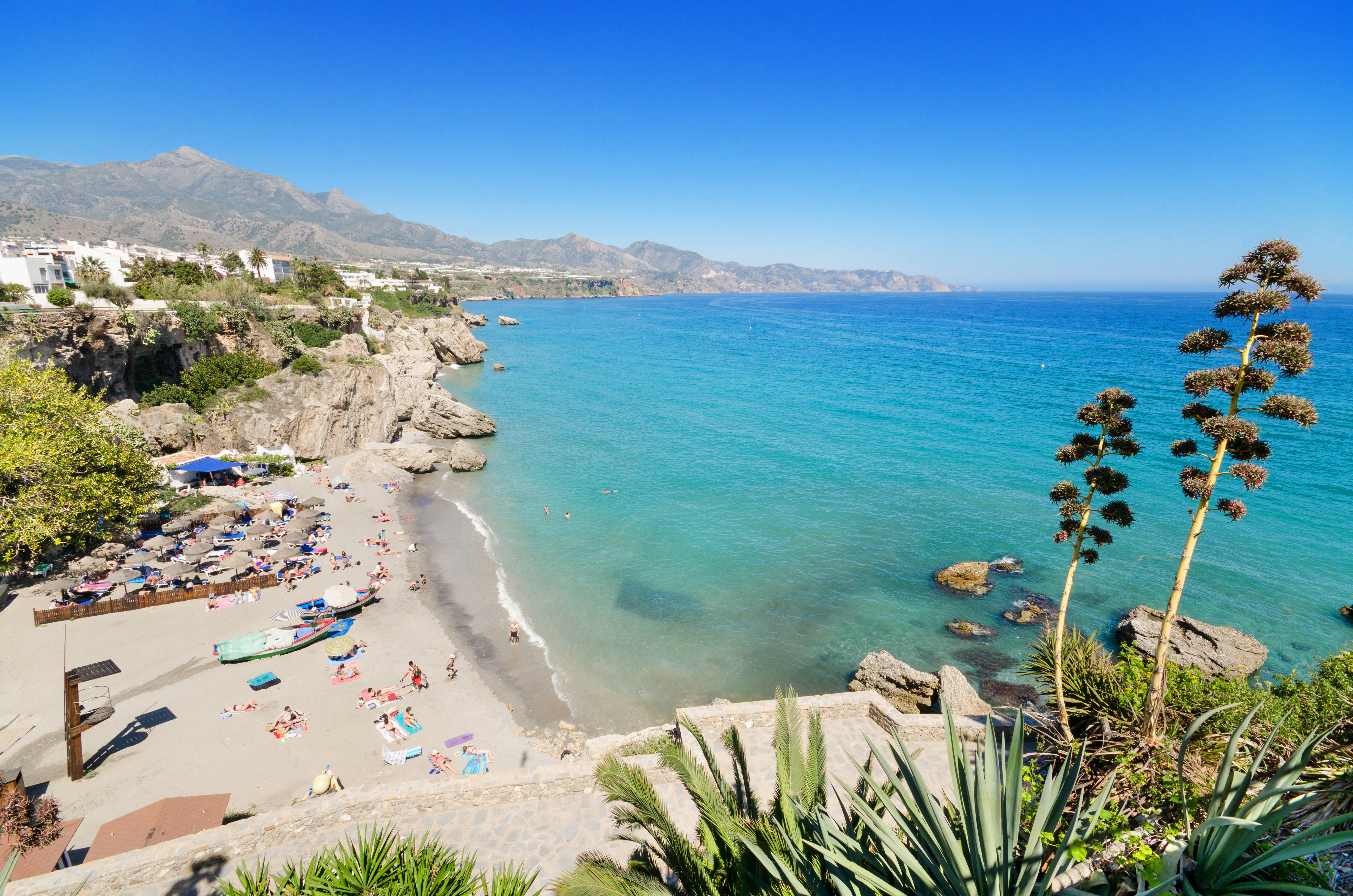 Smuk strand i Nerja på Costa del Sol med turkisblåt vand og bjerglandskab