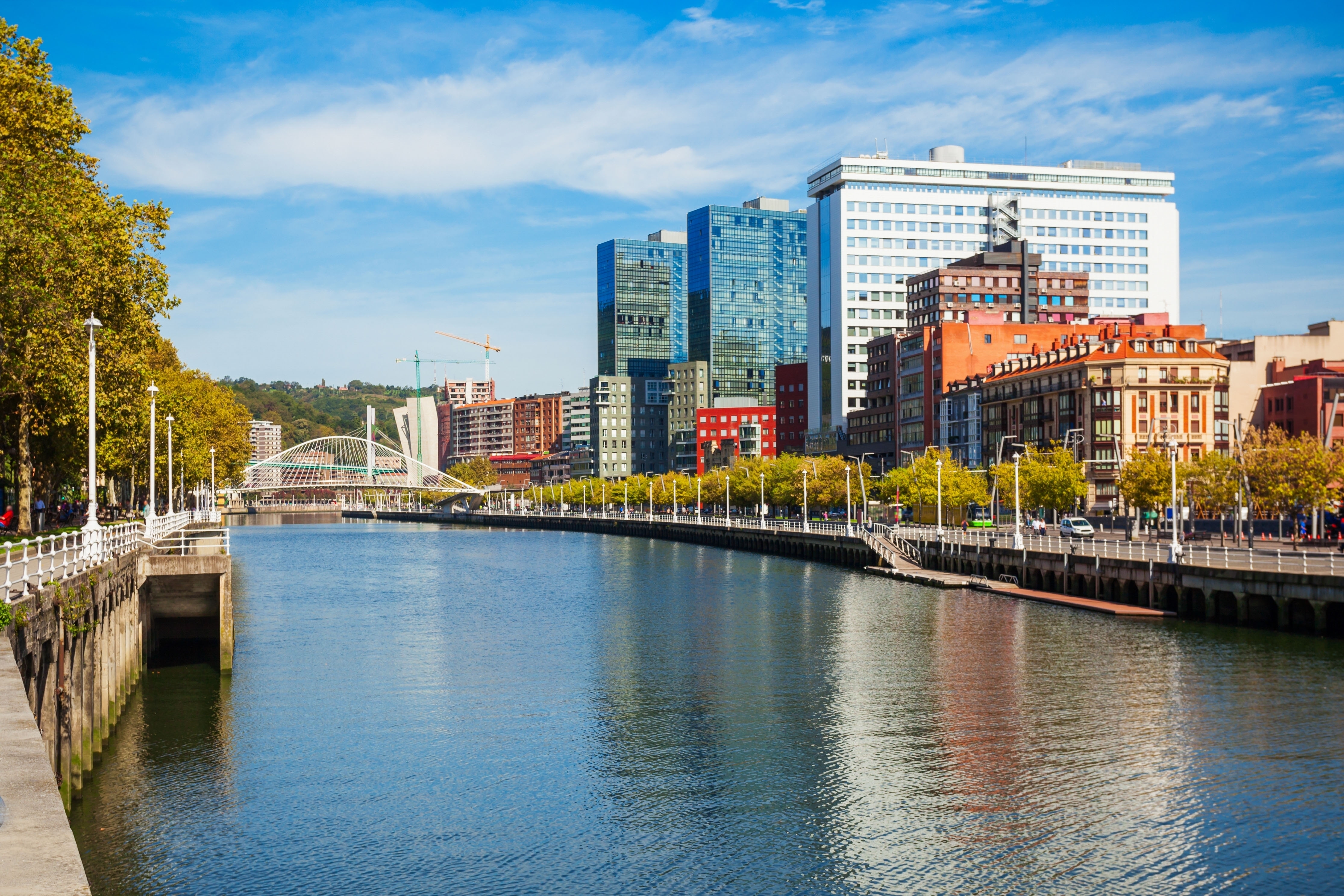 Nervion-floden i centrum af Bilbao med moderne arkitektur og broer langs flodpromenaden - oplevelsesrigt udgangspunkt for solformørkelsesrejsen til Baskerlandet