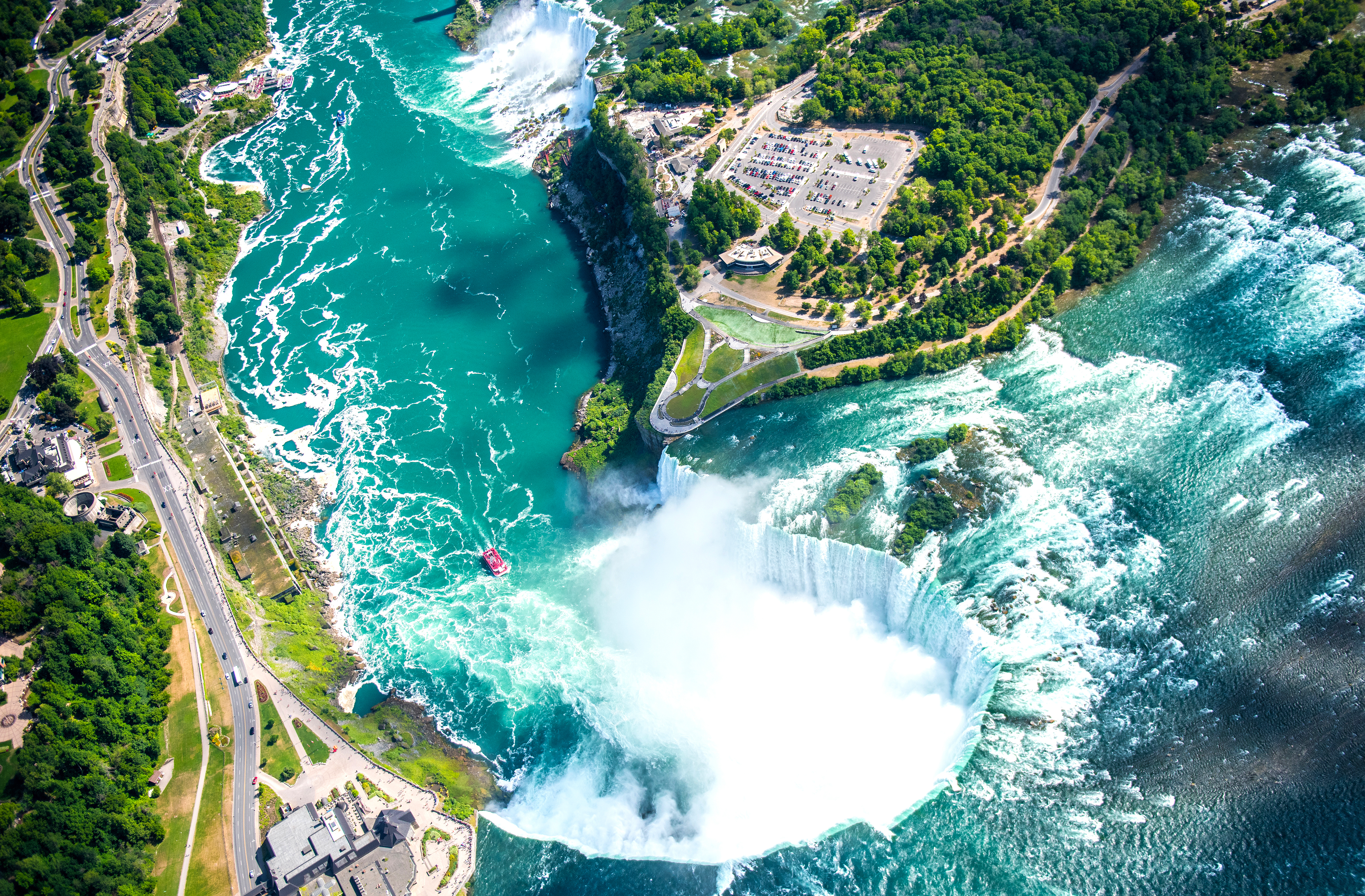 Spektakulært luftfoto af Niagara Falls med turkisblåt vand og regnbue i tågen