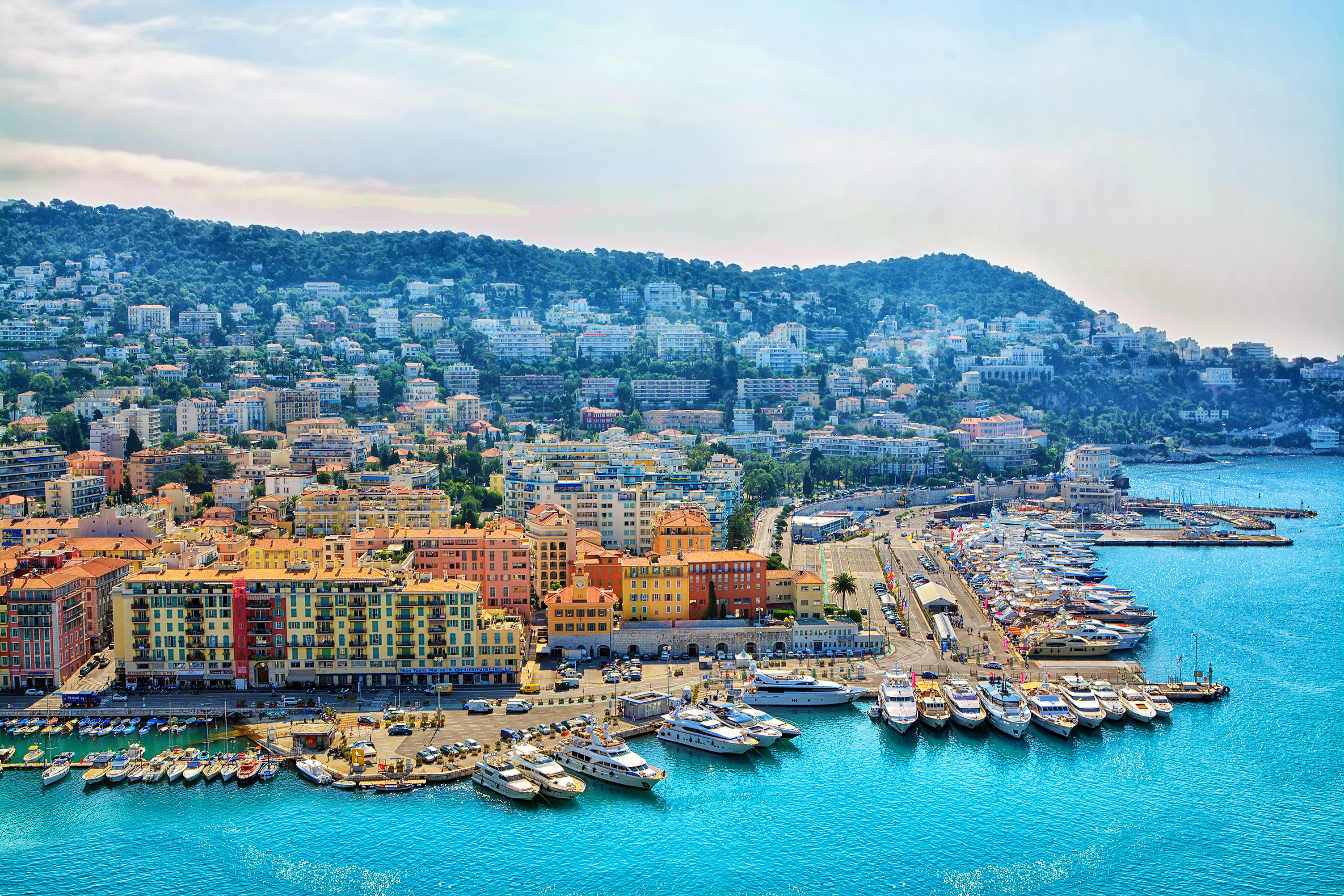 Smuk udsigt over Nice havn med farverige bygninger og luksusyachter på den franske riviera