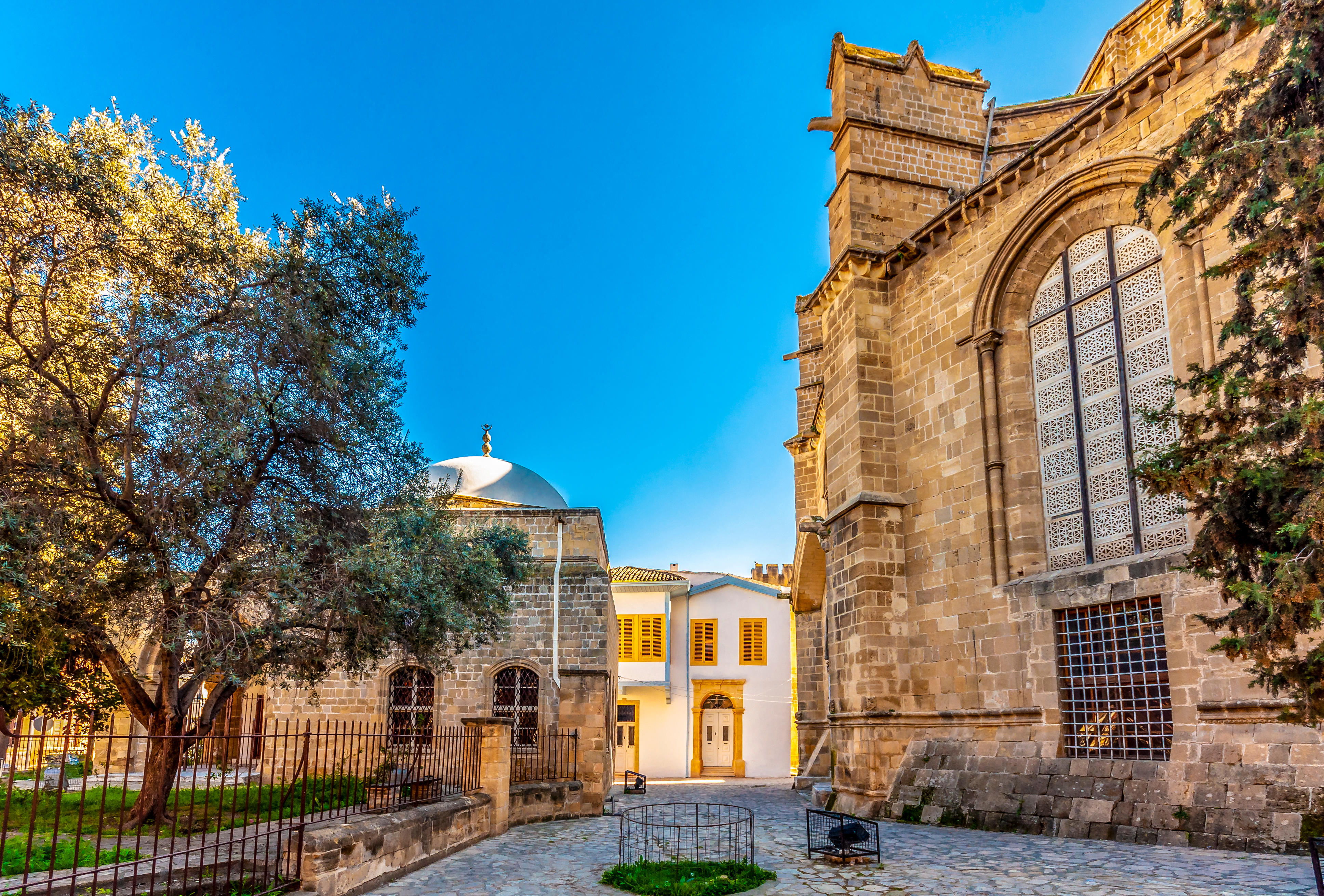 Hyggelig gågade med udendørs caféer og historiske bygninger i den gamle bydel af Nicosia, hovedstaden i Nordcypern, hvor lokale og turister nyder den mediterrane stemning