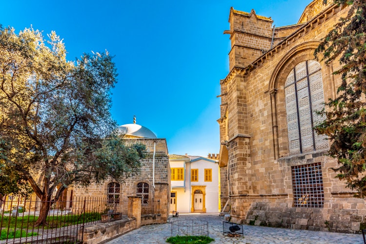 Hyggelig gågade med udendørs caféer og historiske bygninger i den gamle bydel af Nicosia, hovedstaden i Nordcypern, hvor lokale og turister nyder den mediterrane stemning