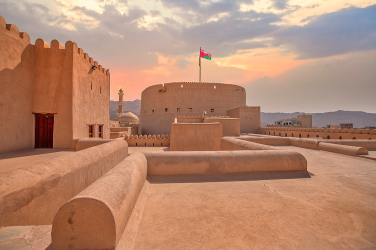 Det historiske Nizwa Fort i Oman med traditionel arabisk arkitektur under blå himmel, en vigtig kulturel seværdighed på rejser til Mellemøsten