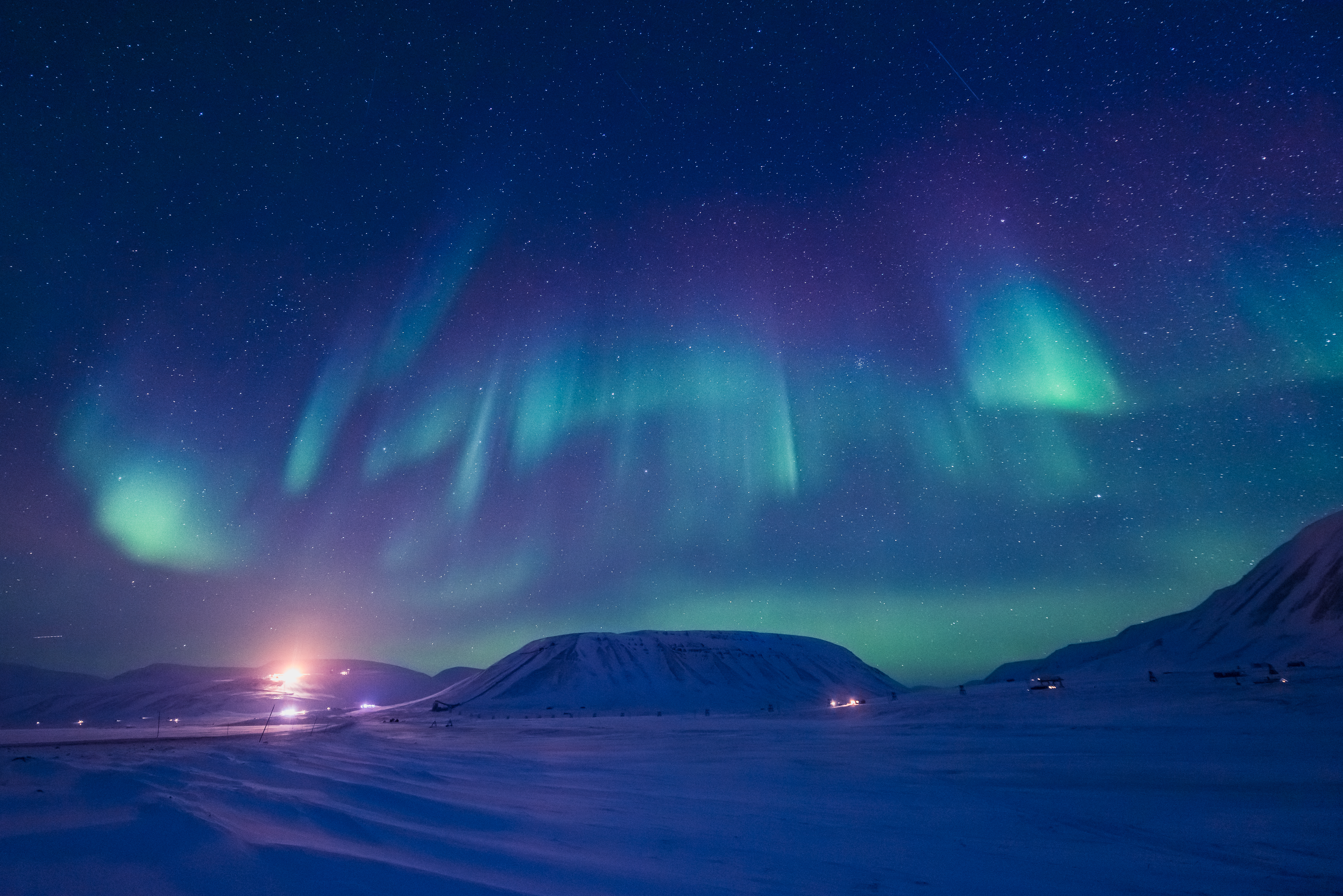 Nordlys aurora borealis over snedækket arktisk landskab i Norge