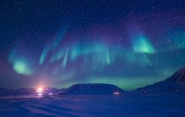 Nordlys aurora borealis over snedækket arktisk landskab i Norge