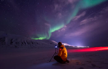 Fotograf optager det spektakulaere nordlys under stjerneklar himmel i det arktiske Norge