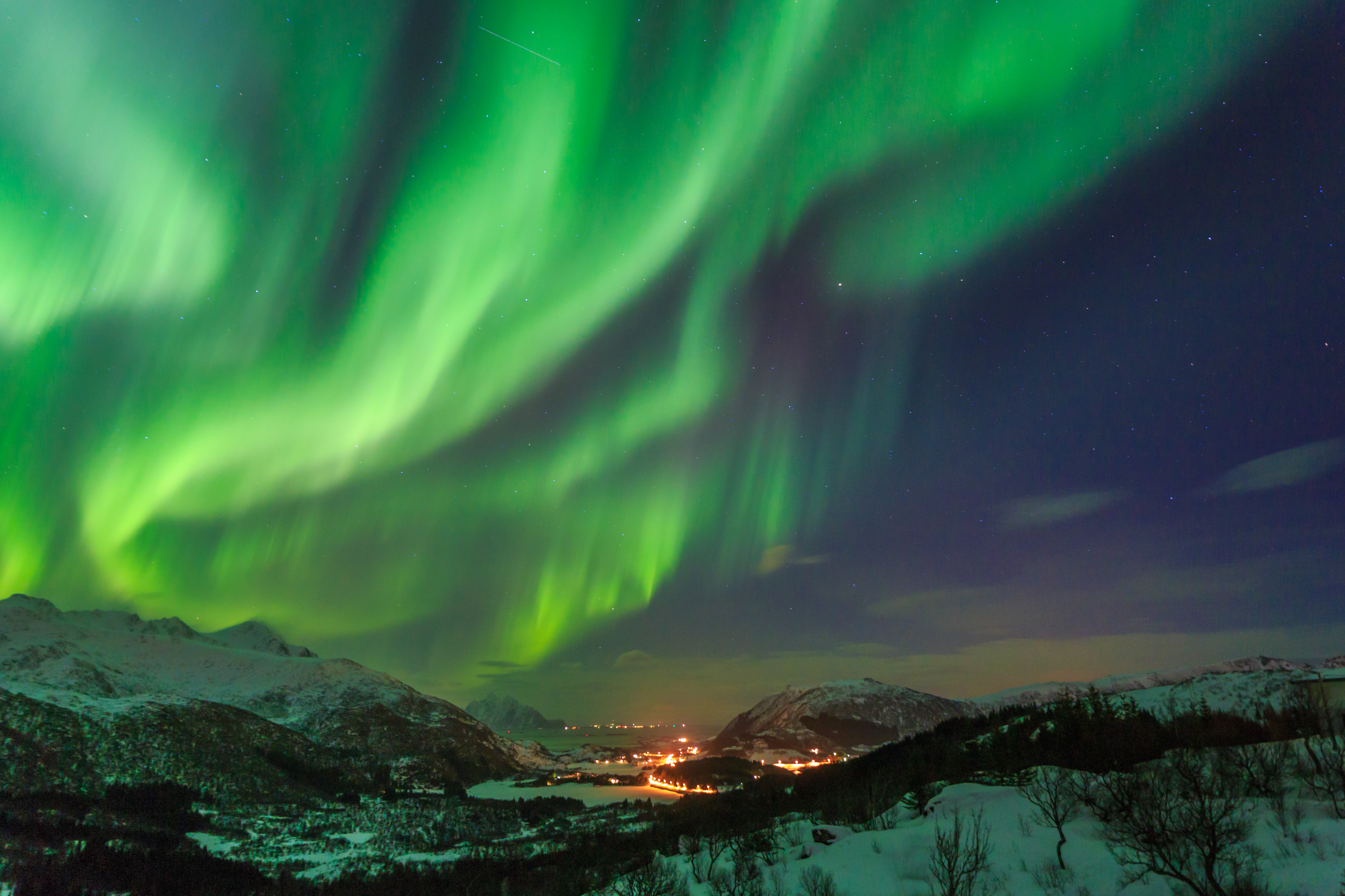Nordlys danser over snedækkede bjerge i Norge - magisk vinteroplevelse i Arktis