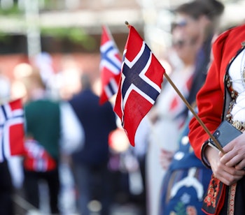 Festlig fejring af Norges nationaldag (17. maj) med traditionelle bunader og norske flag, der viser landets rige kulturarv