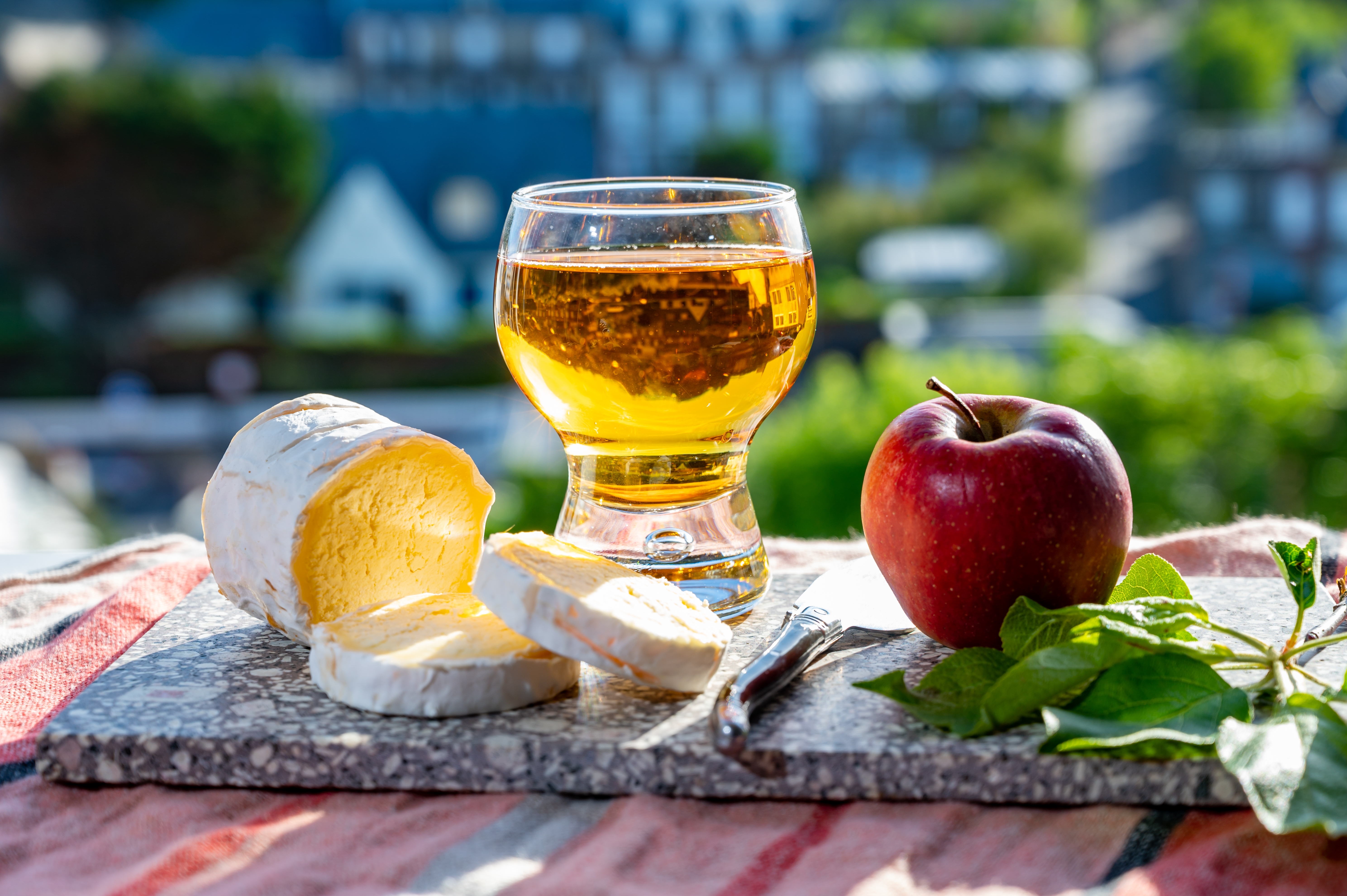 Traditionelle normanniske specialiteter med den karakteristiske Neufchâtel-ost og mousserende æblecider serveret med udsigt til de maleriske huse i Etretat-landsbyen i Normandiet
