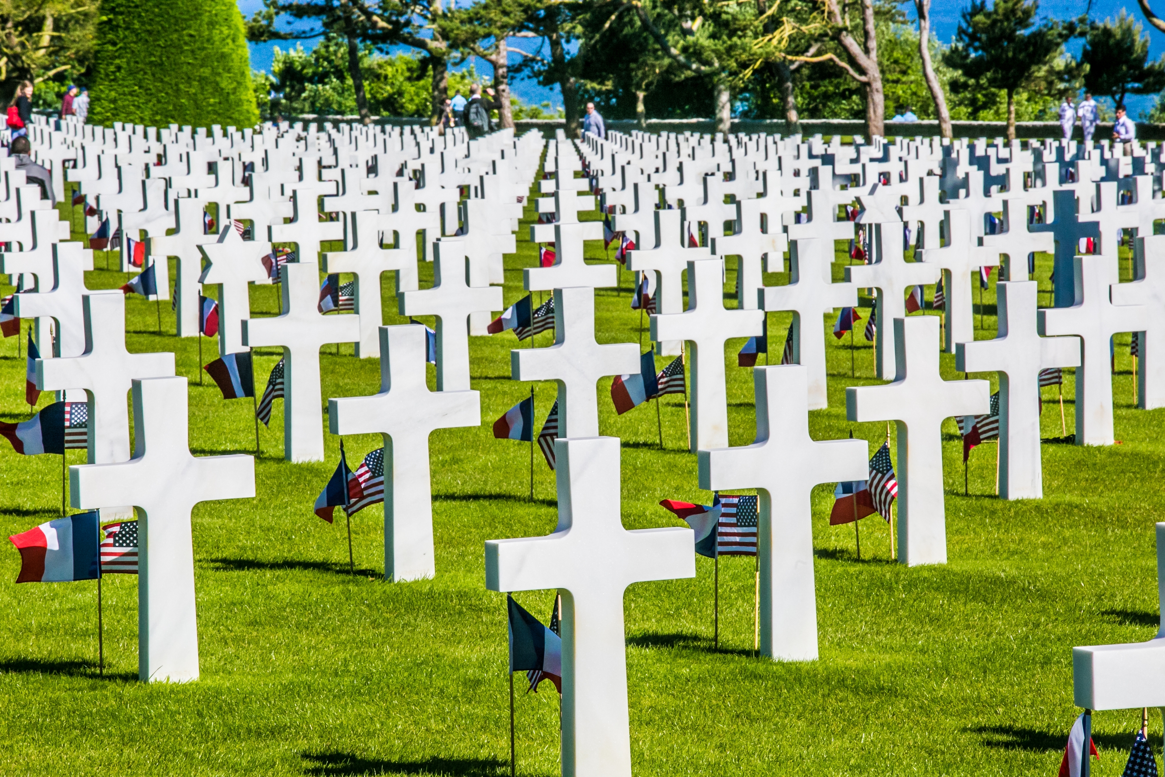 Amerikansk militær kirkegård i Normandy Frankrig med hvide kors og amerikanske flag til ære for Anden Verdenskrig helte