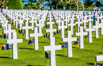 Amerikansk militær kirkegård i Normandy Frankrig med hvide kors og amerikanske flag til ære for Anden Verdenskrig helte