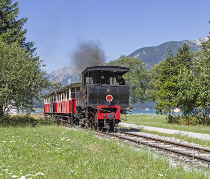 Historisk damptogsattraktion ved Achensee i Tyrol, Østrig - nostalgisk damplever med røg fra skorstenen, populær turistoplevelse i de østrigske alper