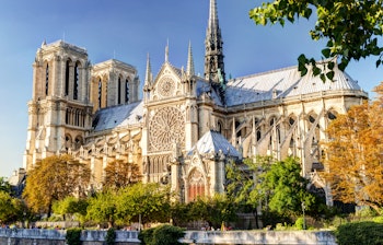 Den historiske Notre Dame katedral i Paris med sin gotiske arkitektur ved Seinen på en solrig sommerdag