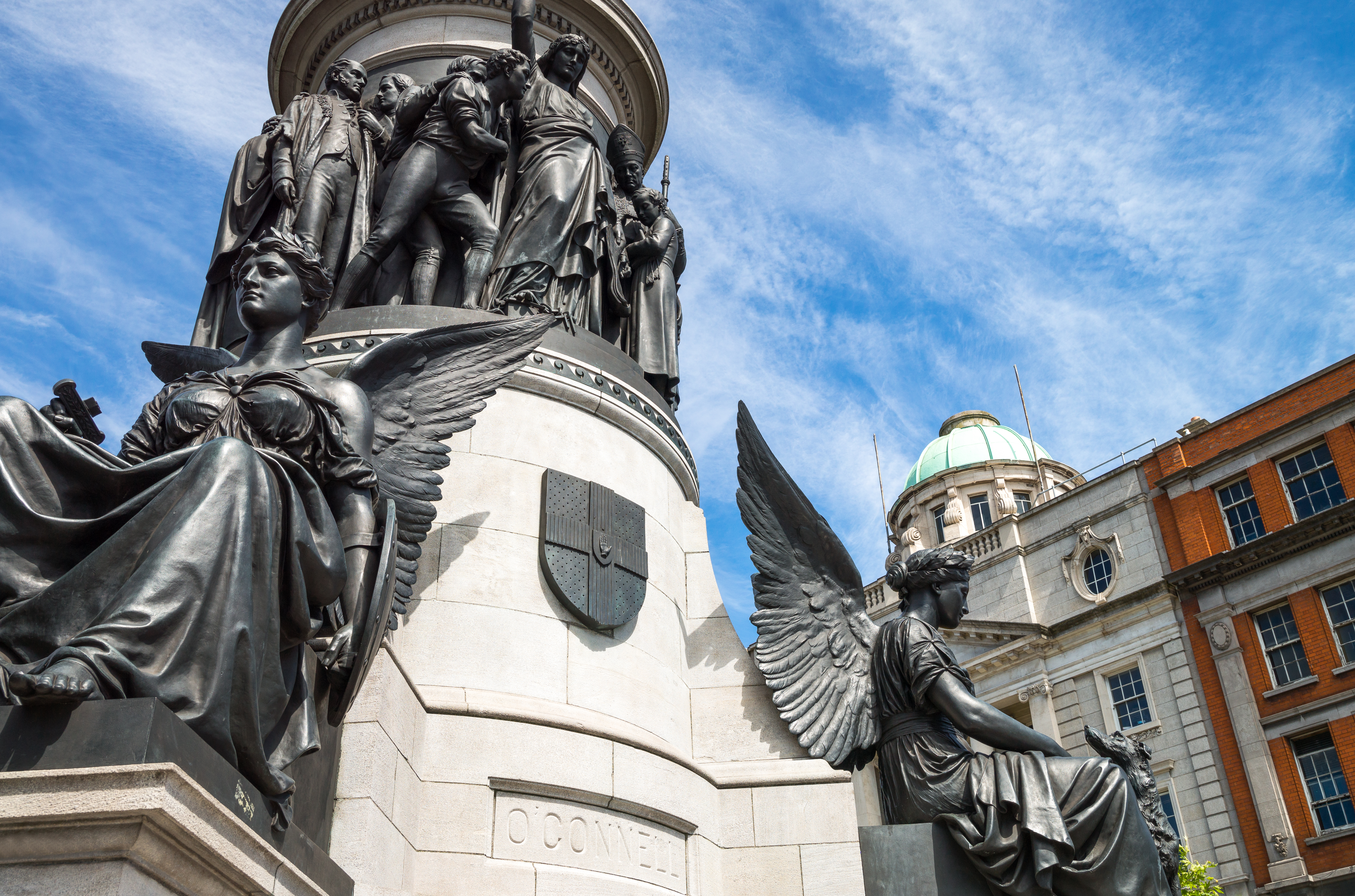 Detaljeret nærbillede af O'Connell monumentet på O'Connell Street i Dublin, Irland, med bronzestatuer af vingede engle ved soklen