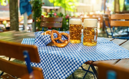Traditionelle ølkrus med friske bretzels på Oktoberfest i München, Tyskland