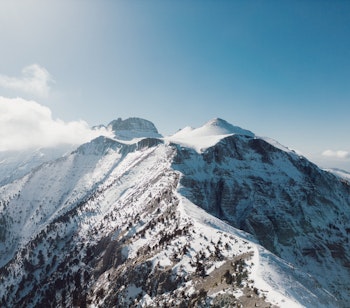 Luftfoto af det snedækkede Olympus-bjerg i Grækenland, gudernes mytologiske hjem der rejser sig 2.918 meter over havet