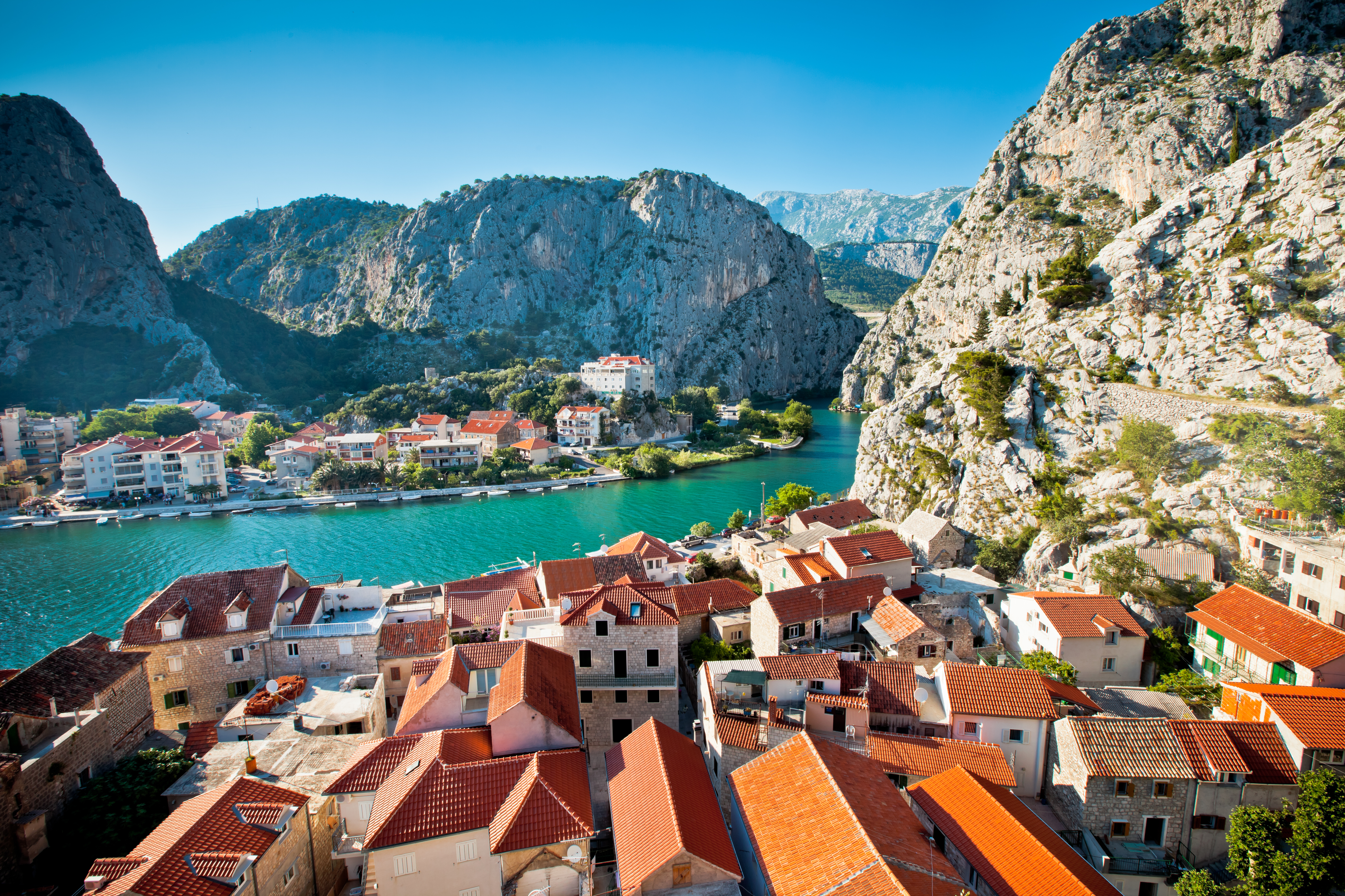 Panoramaudsigt over den historiske by Omis med den turkisblå Cetina-flod, der snor sig mellem de majestætiske bjerge i Kroatien