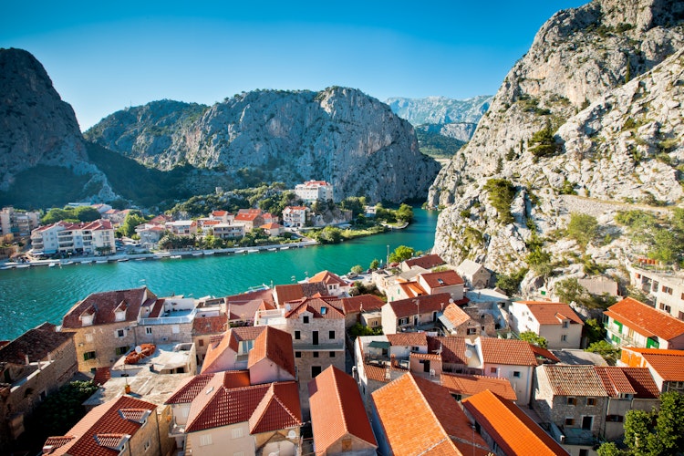 Panoramaudsigt over den historiske by Omis med den turkisblå Cetina-flod, der snor sig mellem de majestætiske bjerge i Kroatien