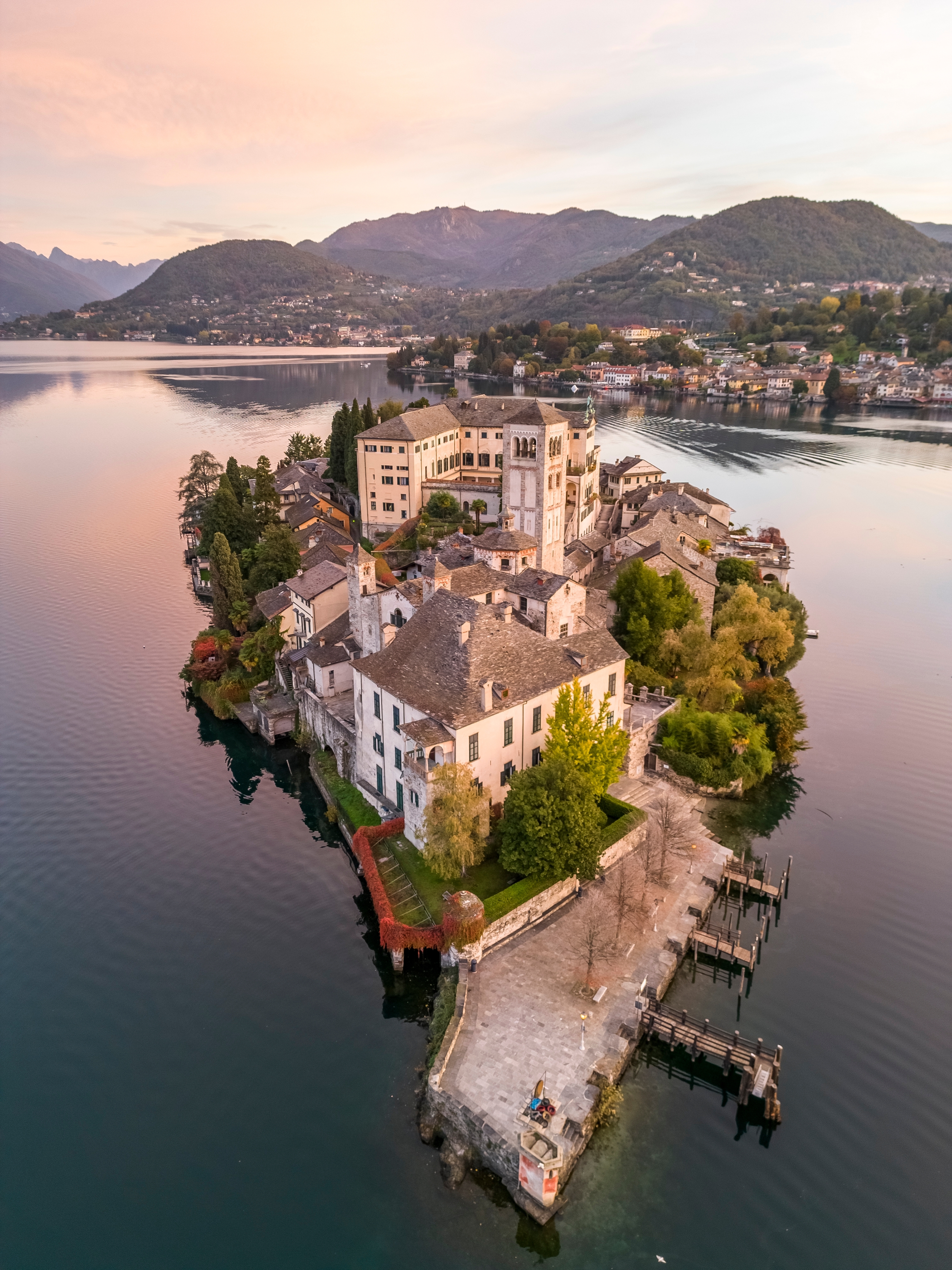 San Giulio-øen ved solopgang på den smukke Orta-sø med efterårsfarver i Piemonte, Norditalien