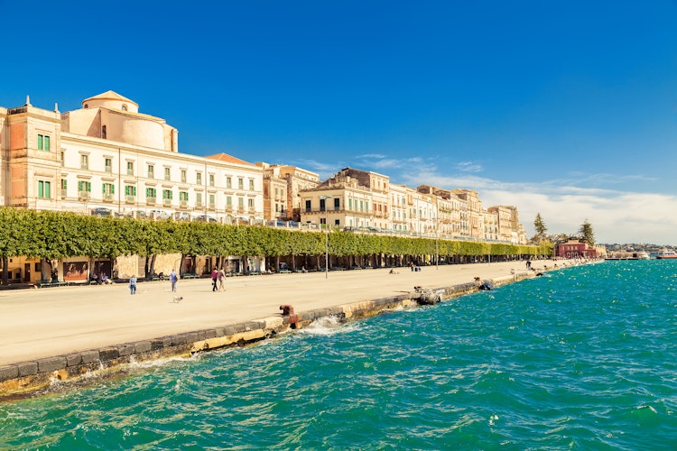 Smuk havnefront i Ortigia på Sicilien med historiske bygninger og turkisblåt middelhav