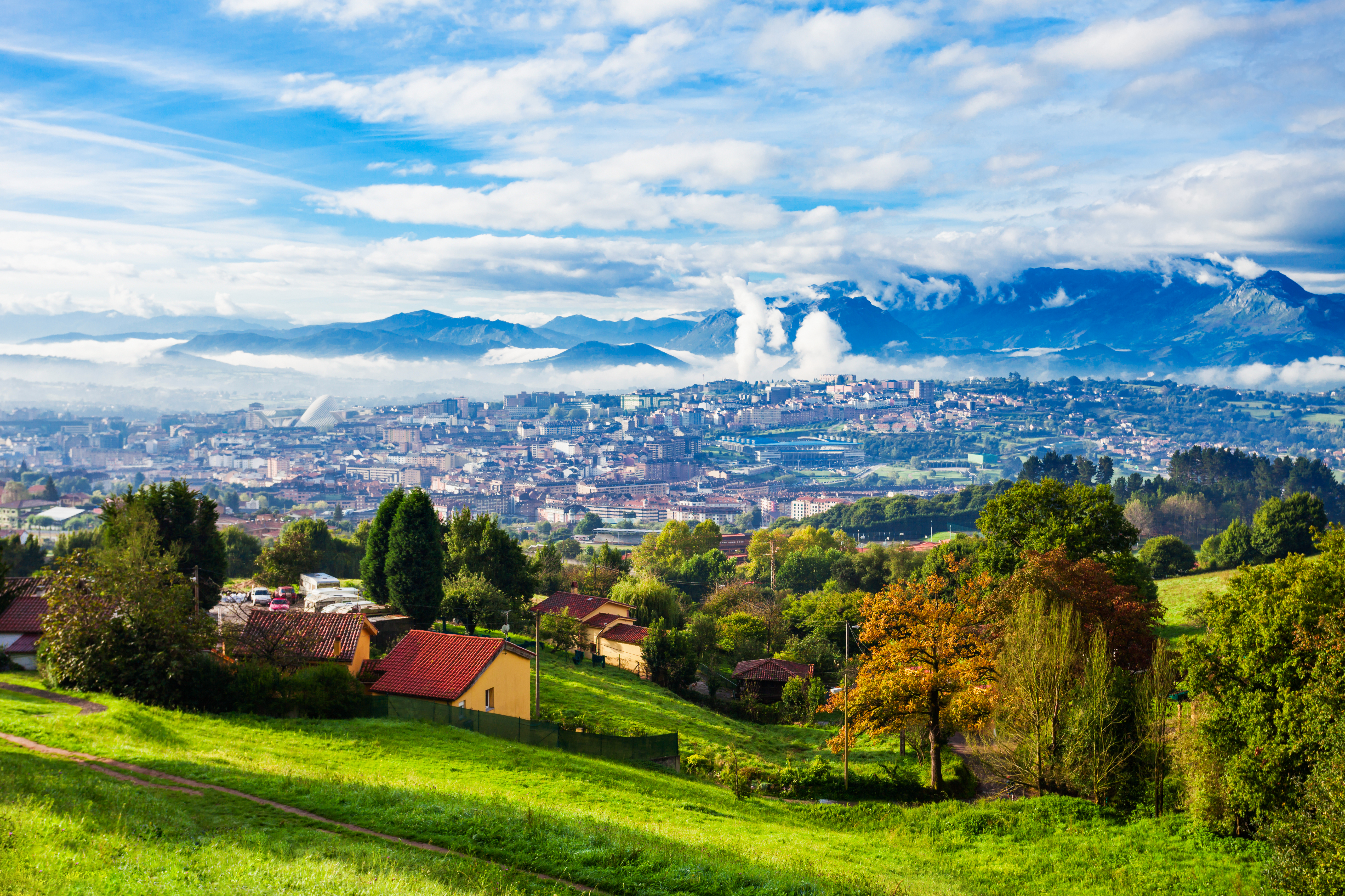Panoramaudsigt over Oviedo by med Santa Maria del Naranco kirke og asturianske bjerge i Nordspanien