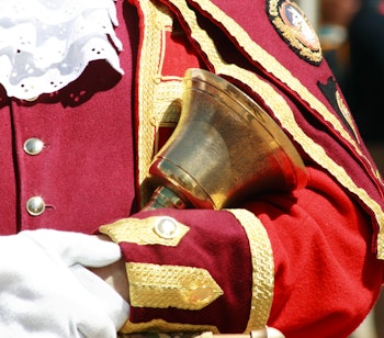 Traditionel byudråber i rød uniform med gulddetaljer forkynder en meddelelse i Oxford, England