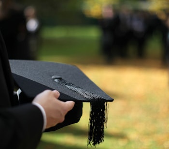 Kandidat holder sort morterbrætshue under dimissionsceremoni på Oxford Universitet i efteråret